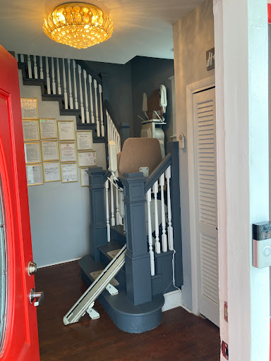 A glimpse of a stylish interior featuring a red entrance door and a staircase leading to the upper level.