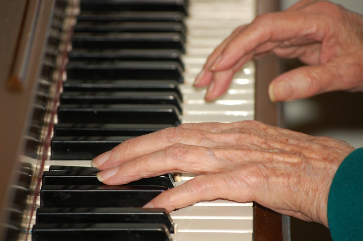 Hands playing piano keys.