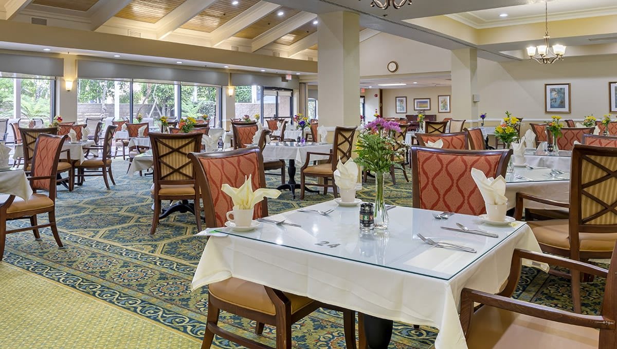 An elegant restaurant dining area with neatly arranged tables and chairs, featuring tasteful decor.