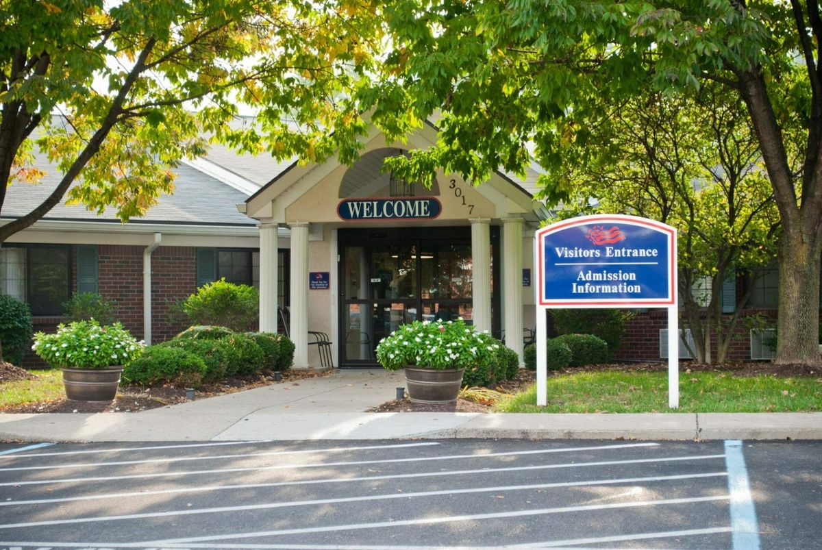 The image shows the entrance of a visitor center surrounded by greenery.