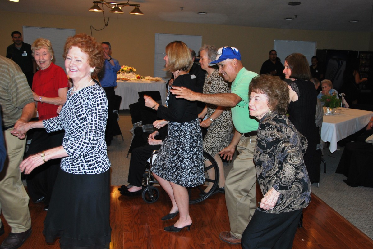 A group of people dancing and having fun indoors at a party.