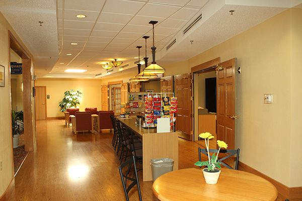 A cozy kitchen and lounge area with seating, wooden flooring, and warm lighting.