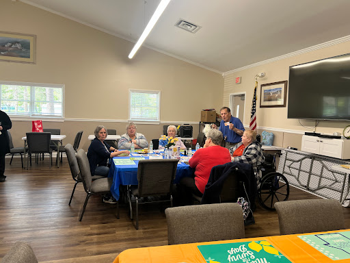 A lively gathering of seniors enjoying a meal and conversation at a community center.
