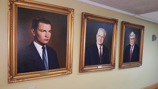 Three formal portraits of men displayed in ornate frames.