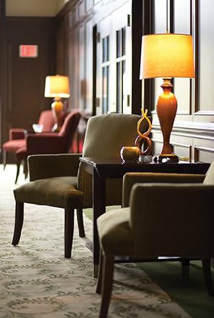 A cozy hotel lounge with comfortable chairs and warm lighting.