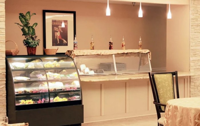 A cozy bakery with a display of desserts and ice cream.
