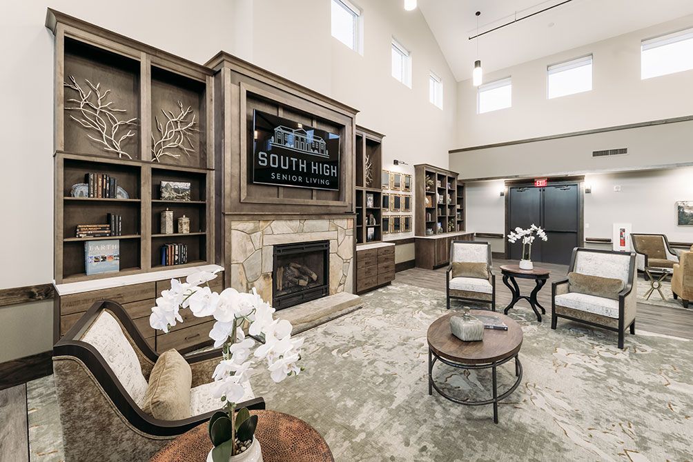 A modern living room featuring a fireplace, elegant furniture, and built-in bookshelves.