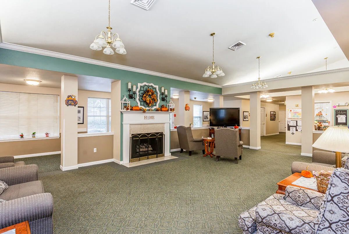 A cozy living room interior with a fireplace, TV, and comfortable seating.