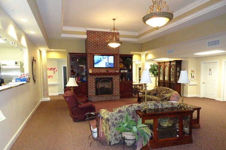 A cozy living room with a fireplace, comfortable sofas, and a television mounted above the mantel.