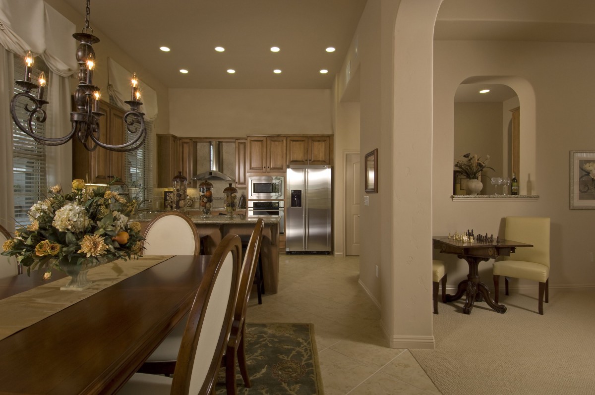 A modern kitchen and dining area with wooden furniture and stainless steel appliances.