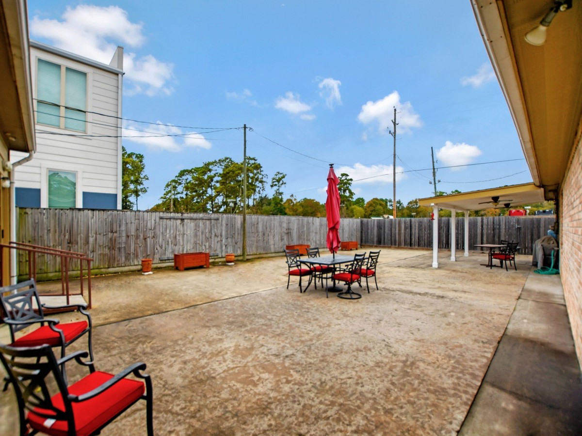 A spacious backyard patio with outdoor seating and an umbrella.