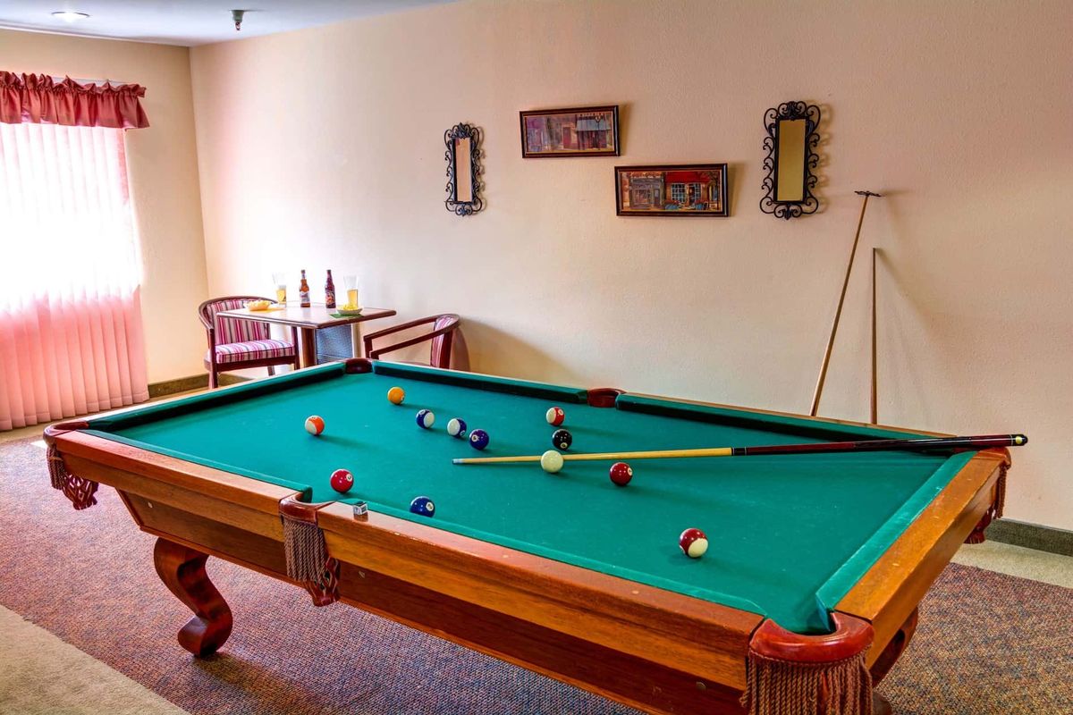 A cozy game room featuring a billiards table set up for play.