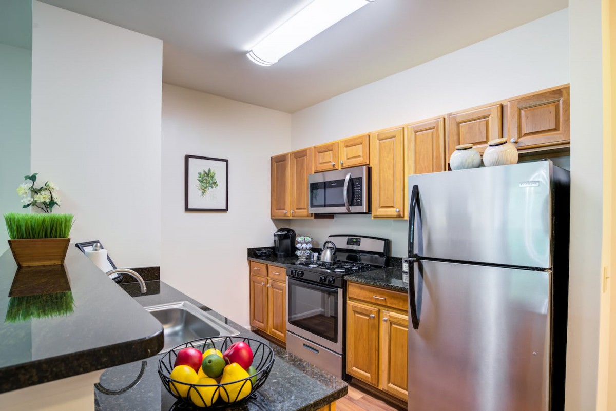 A modern kitchen with stainless steel appliances and wooden cabinets.