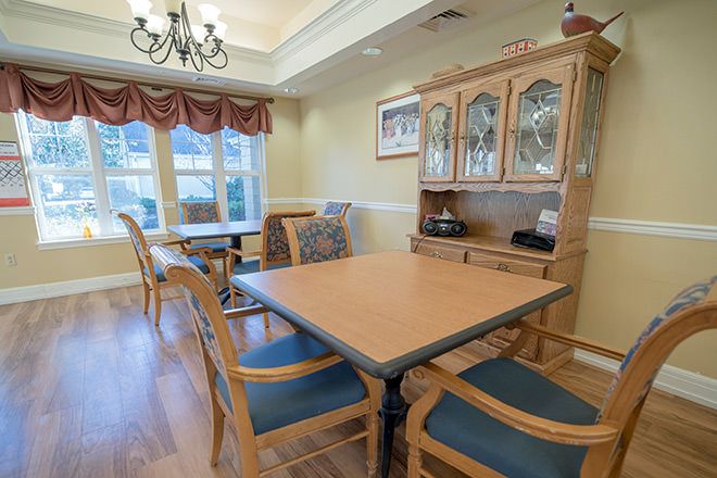 A cozy dining area with wooden furniture and a decorative chandelier.