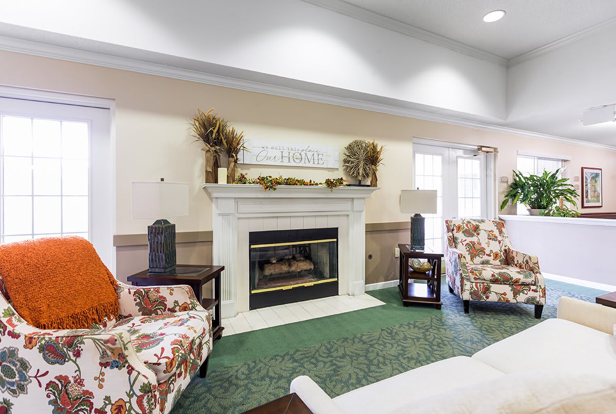 A cozy living room featuring a decorated fireplace and comfortable seating.