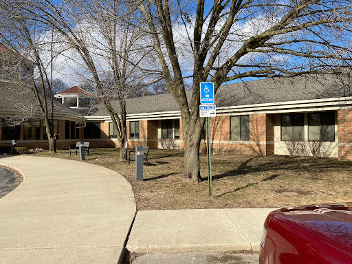 A view of a brick building surrounded by trees on a clear day.