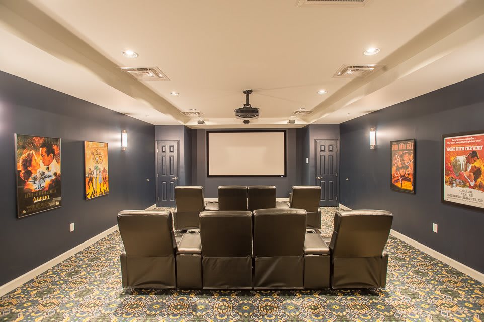 A cozy home theater setup featuring comfortable seating and a large projector screen.