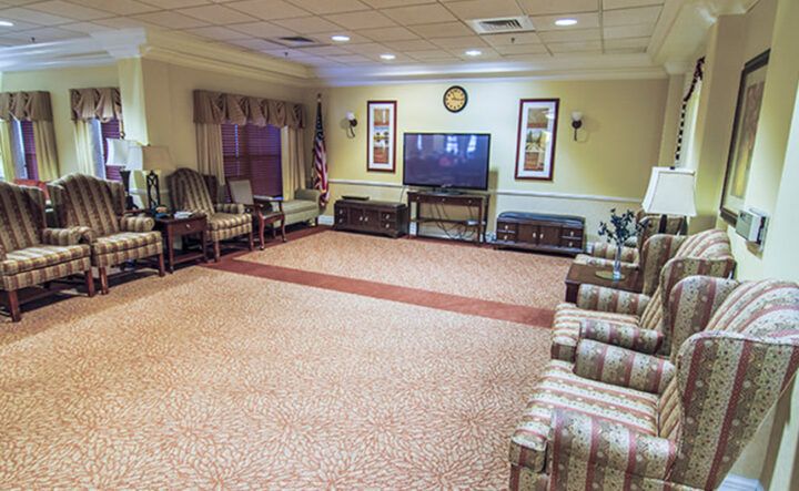 A spacious living room with multiple seating options and a large television.