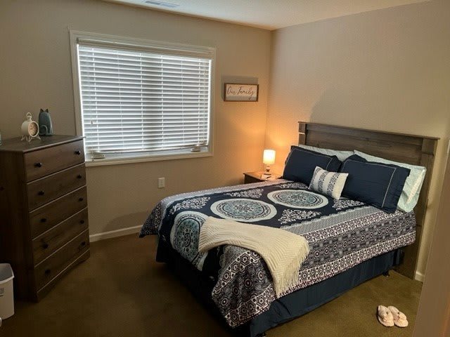A cozy bedroom with a neatly made bed and a soft lamp glow.