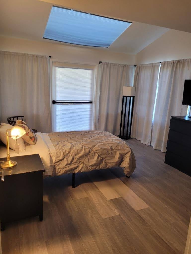 A cozy bedroom with a single bed, neatly arranged furniture, and soft lighting.