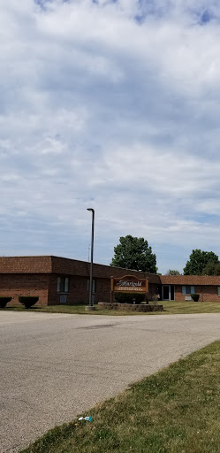 A brick school building under a cloudy sky.