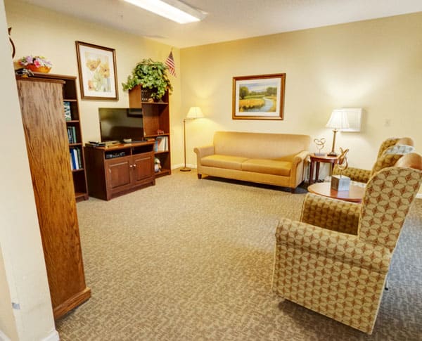 A cozy living room with a sofa, chairs, and a television.