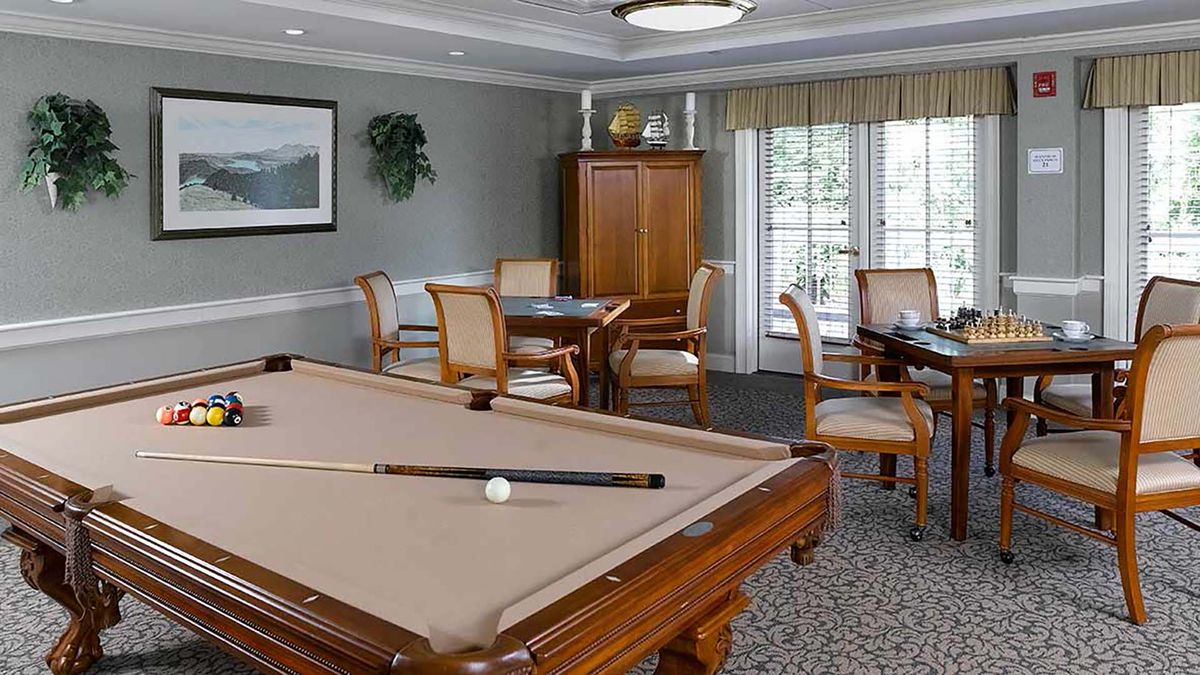 A cozy game room featuring a billiards table and seating area.