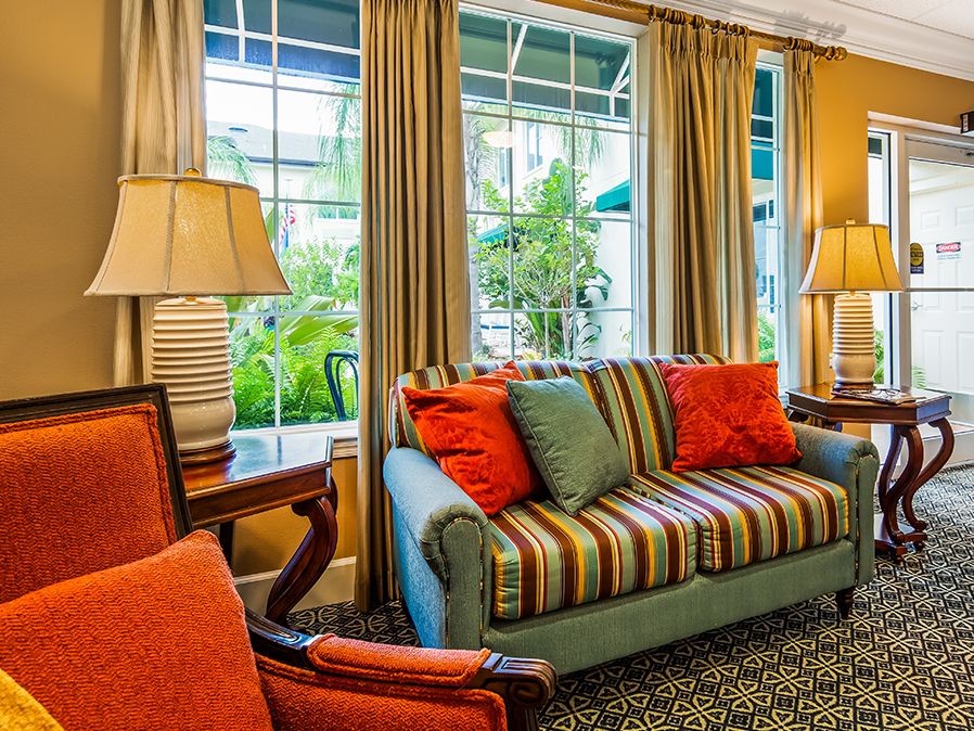 A cozy, well-lit living room with a striped sofa and vibrant cushions.