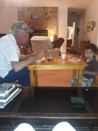A touching moment at the dinner table, sharing a meal and conversation between generations.