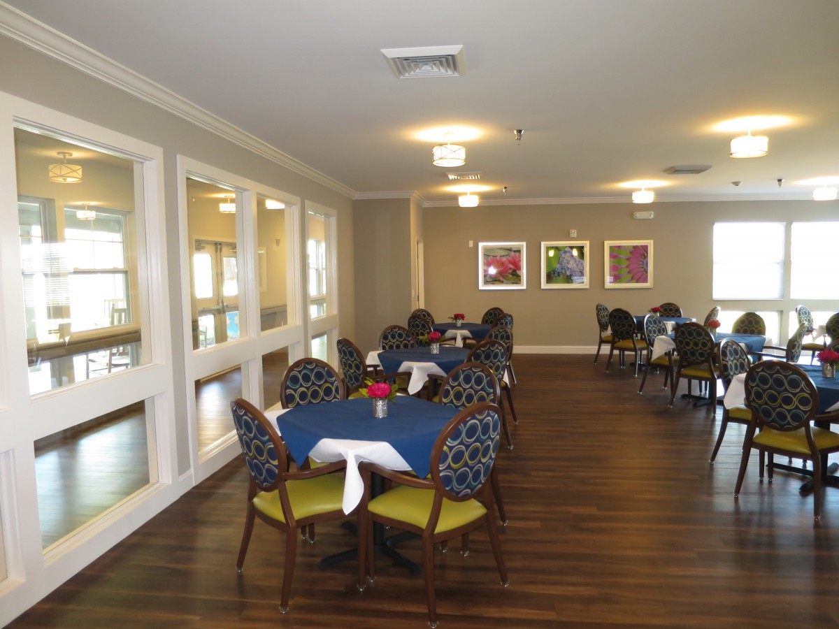 A neatly arranged dining room with round tables and patterned chairs.