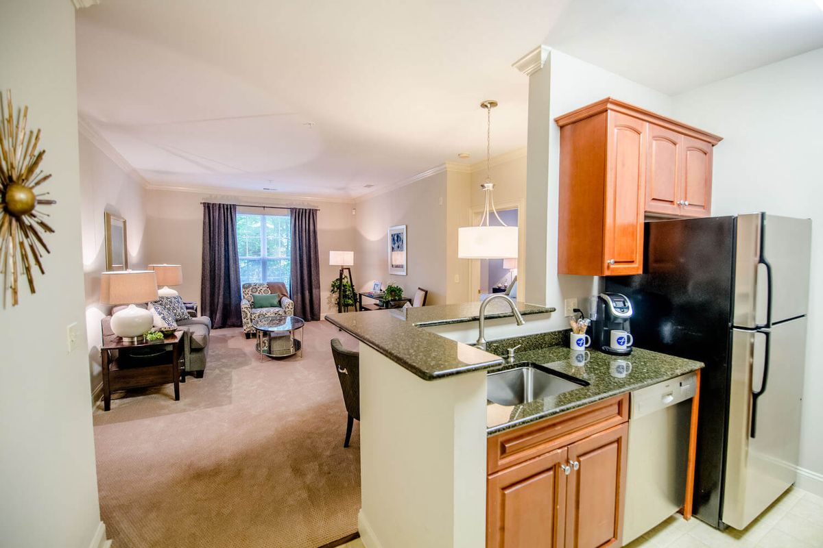 A modern open floor plan featuring a cozy living room and adjacent kitchen area.