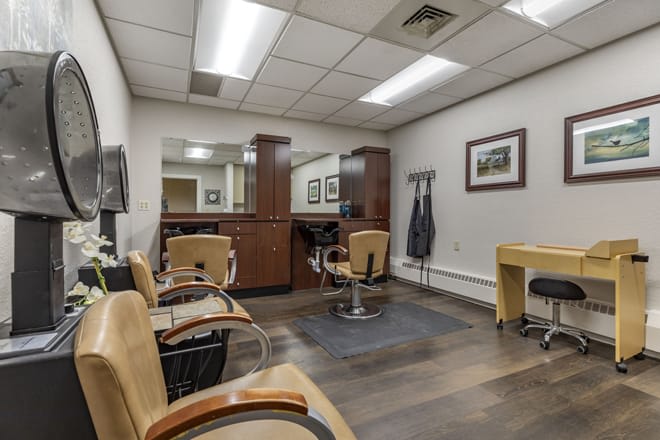 A modern and well-lit interior of a barber shop featuring several styling chairs and large mirrors.