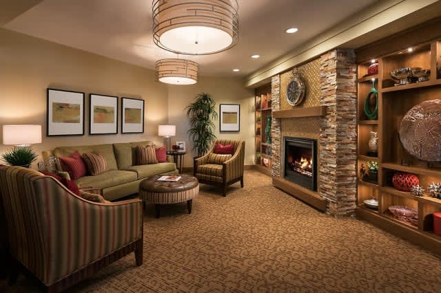 A cozy living room with a modern design featuring comfortable seating, a fireplace, and warm lighting.
