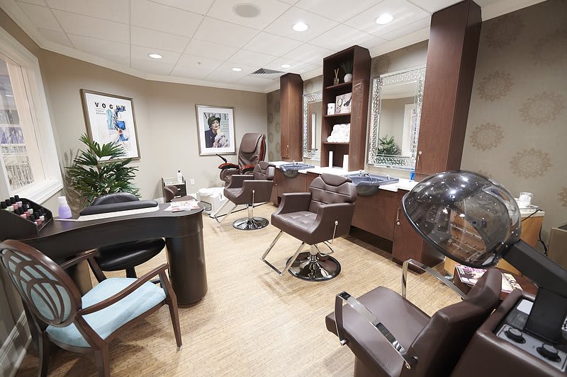 Modern salon interior with chairs and styling stations.