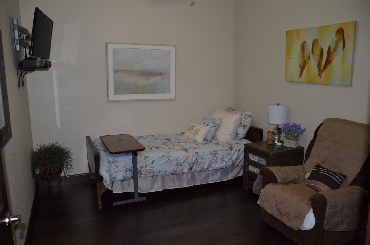 A cozy bedroom with a single bed, nightstand, and artwork on the walls.