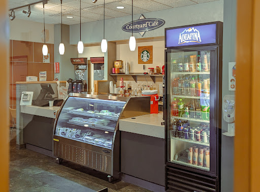 A cozy cafe interior featuring a food display case and a beverage cooler.