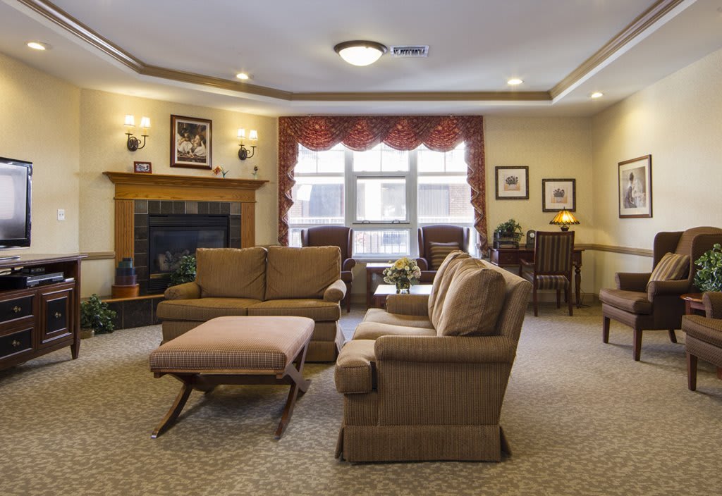 A cozy and well-decorated living room featuring comfortable seating, a fireplace, and ample natural light.