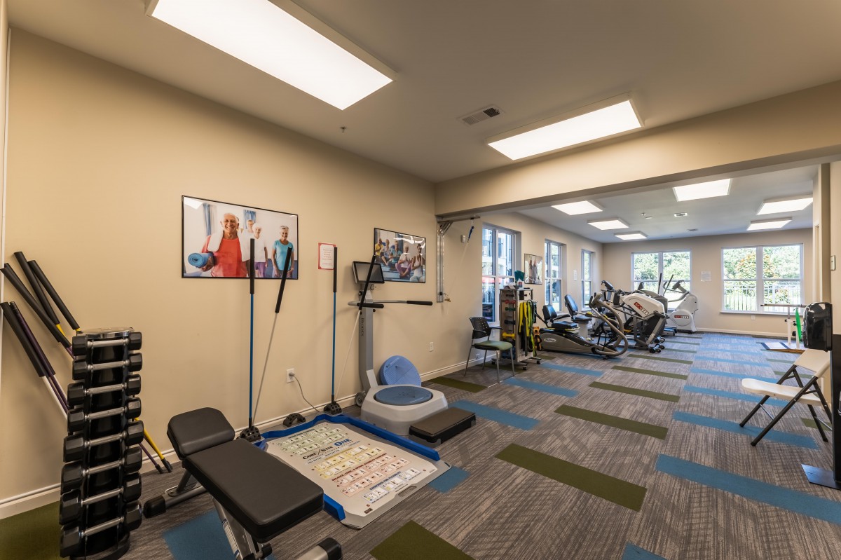 A modern indoor gym with various fitness equipment and exercise machines.