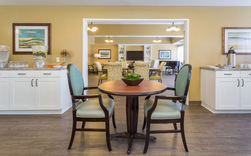 A cozy interior featuring a round table with two chairs in a warmly lit room.