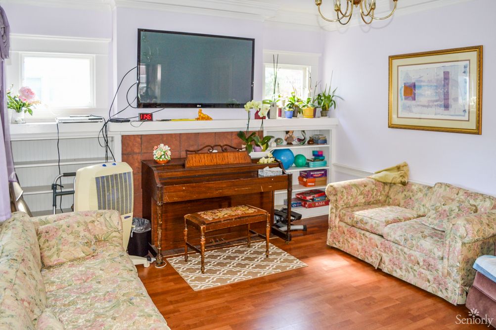 A cozy living room featuring a piano, television, and comfortable seating.