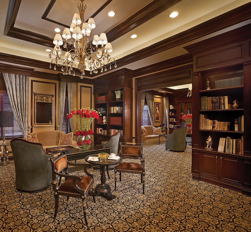 A luxurious library interior with elegant seating and a grand chandelier.