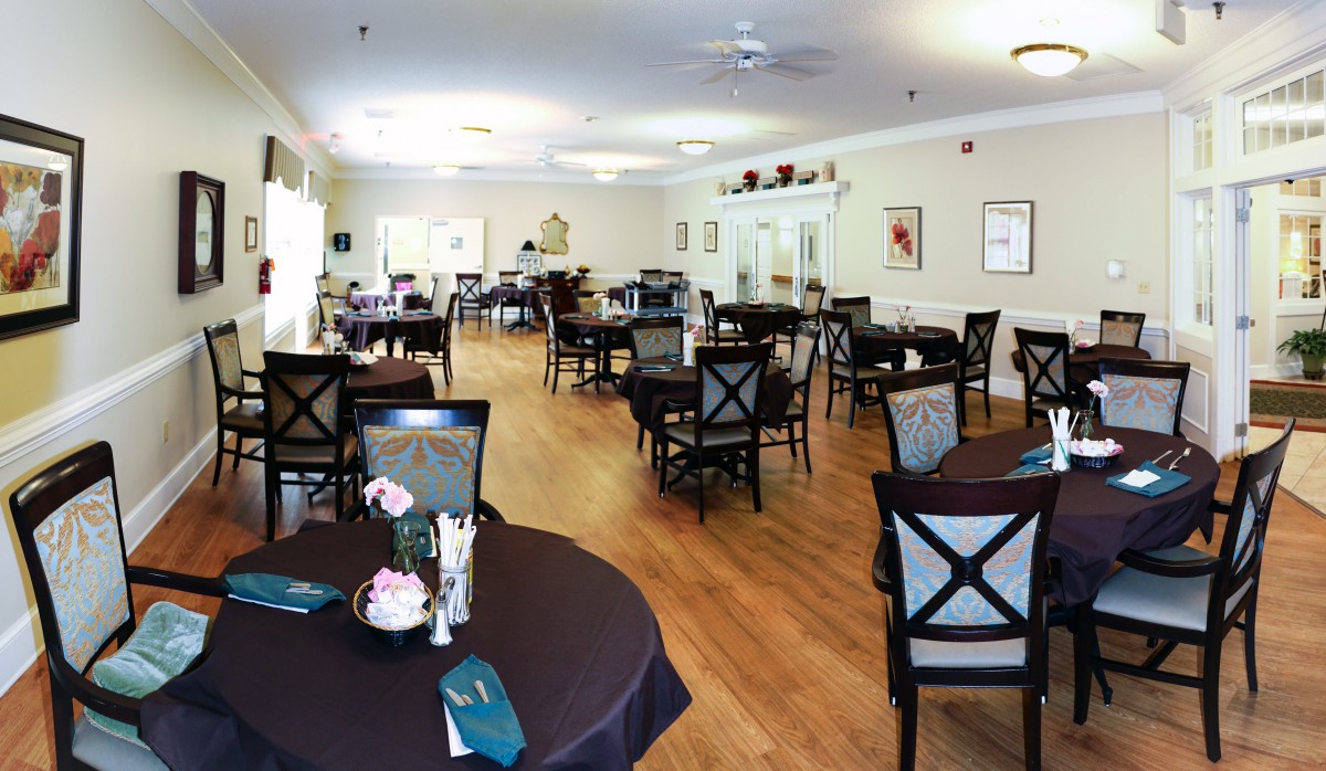 A spacious dining room with neatly arranged tables and chairs, featuring elegant decor.