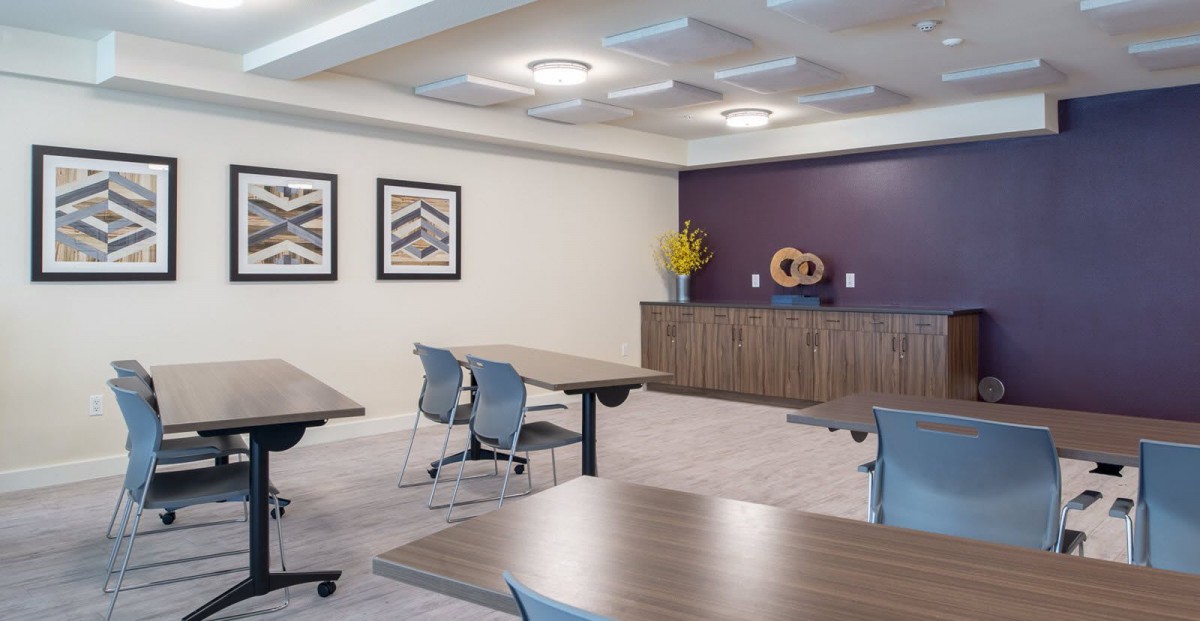 A modern conference room with tables, chairs, and decorative elements.