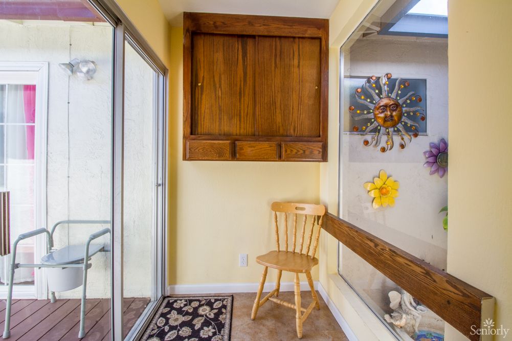 A cozy corner featuring a wooden chair, cabinet, and sun-themed decorations.
