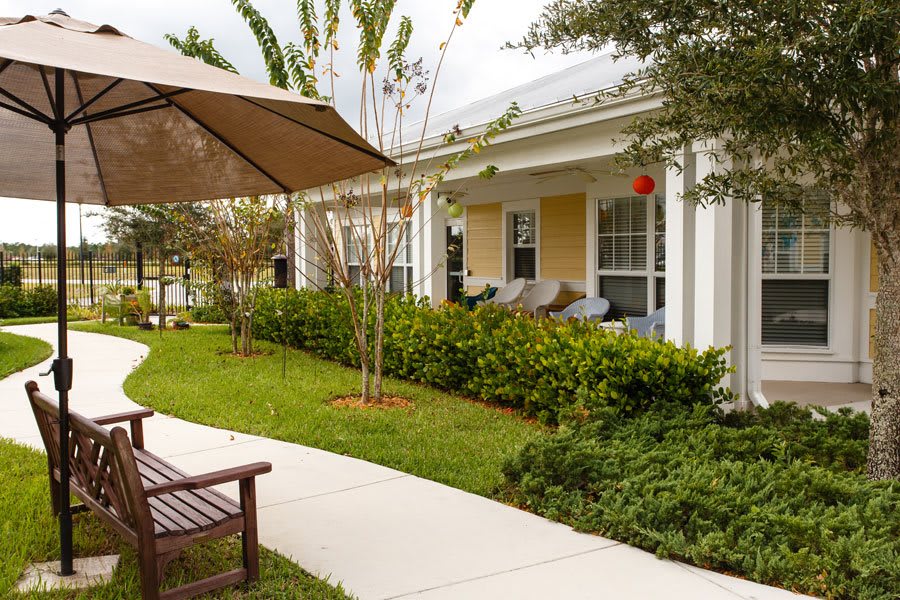 A cozy patio area with outdoor seating, surrounded by a well-maintained garden.