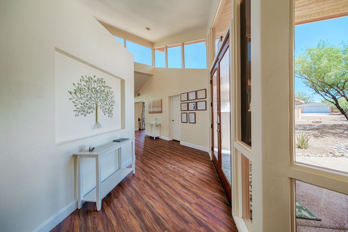 Bright hallway with wood flooring and artwork on the walls.