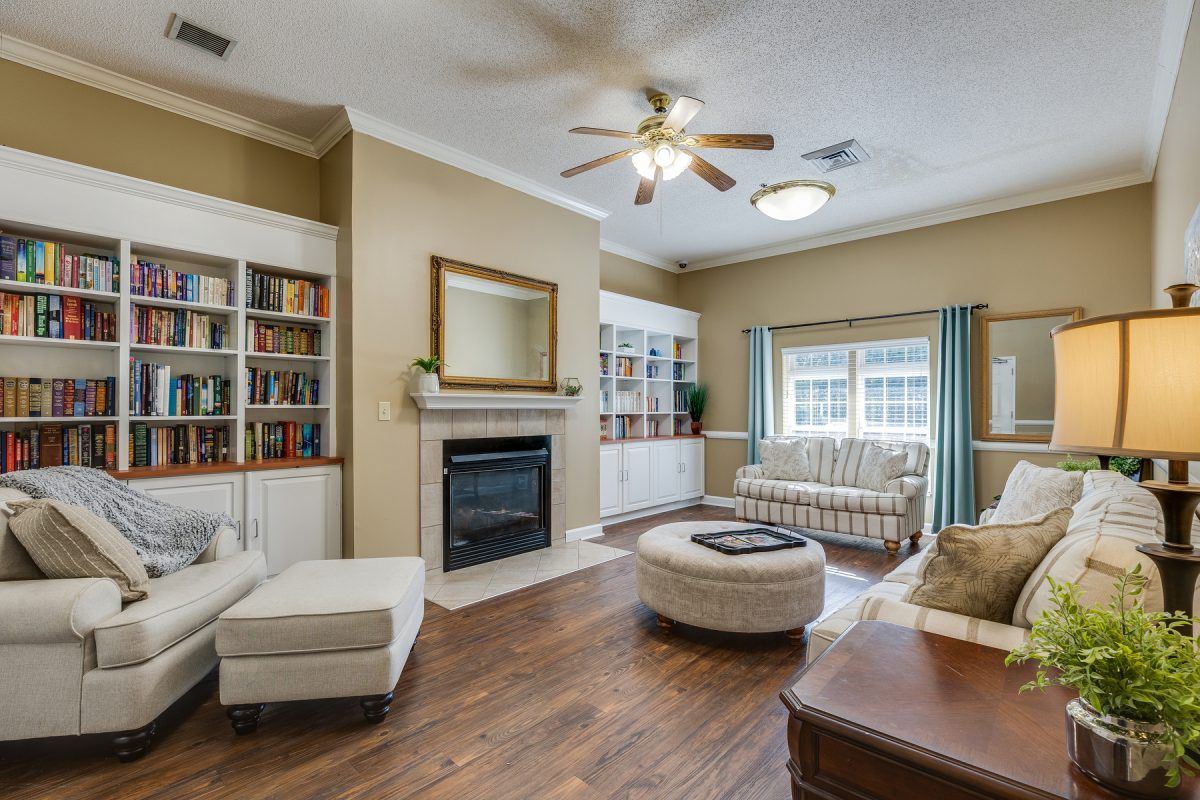 A cozy living room with a fireplace, bookshelves, and comfortable seating.