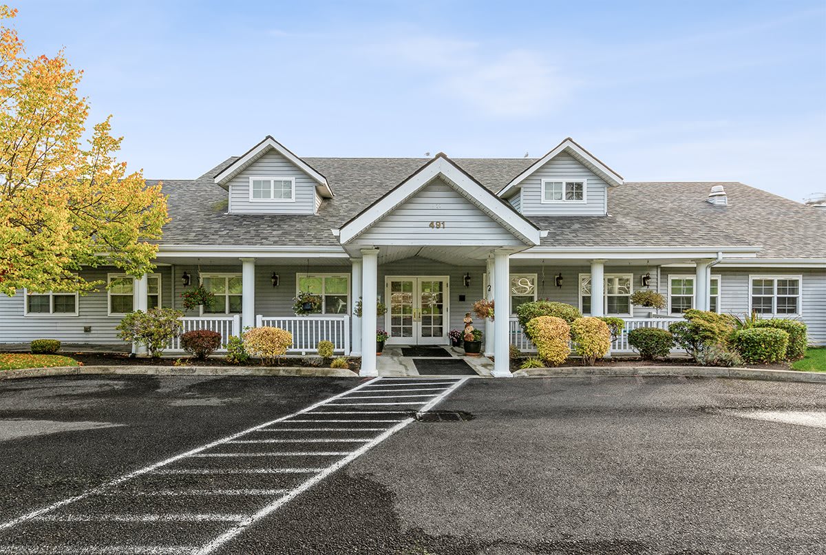 A charming residential house with a front porch and landscaped yard.