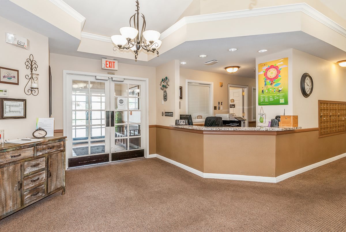 A modern office reception area with a welcoming desk and chandelier.