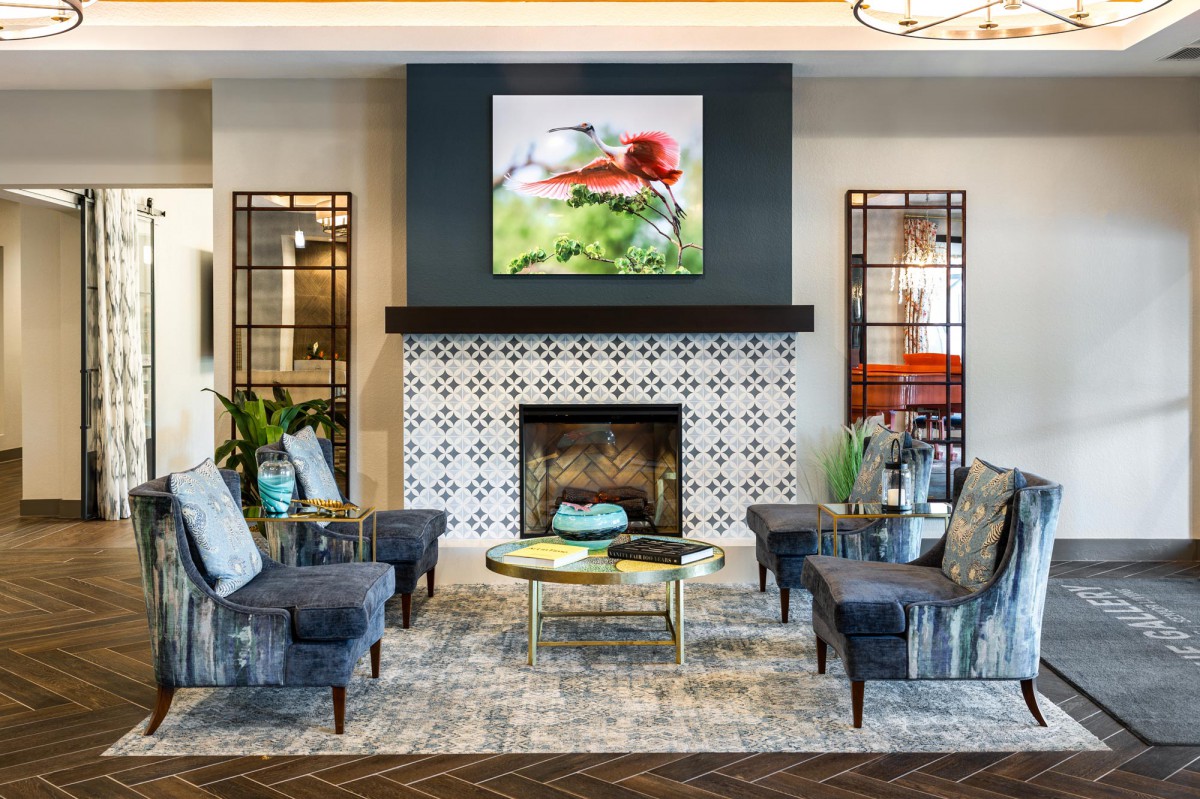 A stylish living room featuring a fireplace, comfortable seating, and vibrant artwork.